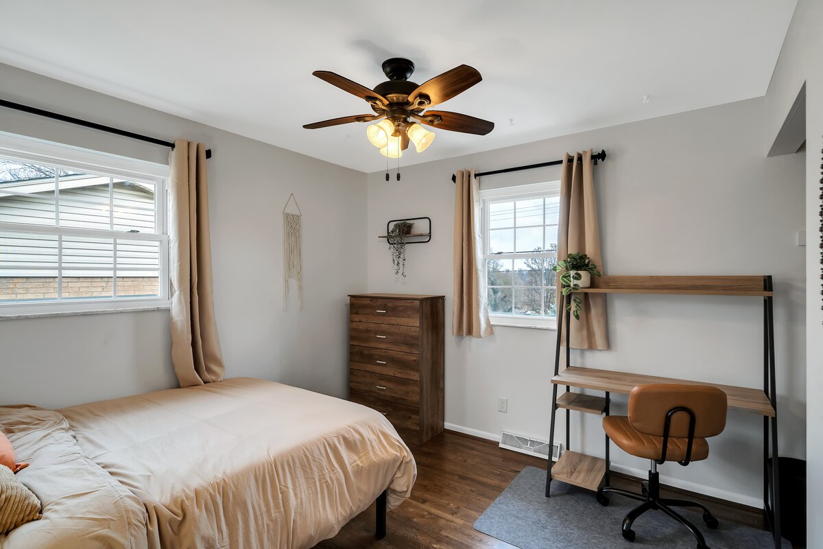 Dhomë gjumi dytësore. Krevat dopio. Tavolinë, komodinë, dollap i vogël. Perde të errëta. Makinë zhurme.