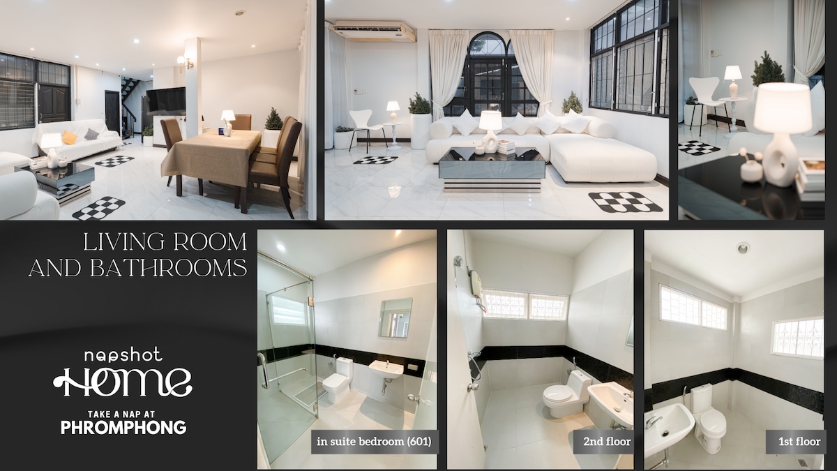 The living room features sleek furnishings, with a spacious white seating area complemented by a dining table. Large windows allow natural light to fill the room. Bathrooms are equipped with modern fixtures, showcasing neutral-colored tiles and ample space.
