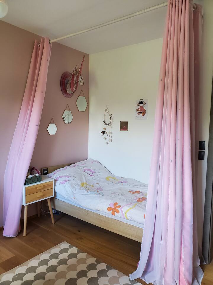 Dječja soba s bračnim krevetom s četiri postera, radnim stolom i klupom za čitanje s mnoštvom knjiga