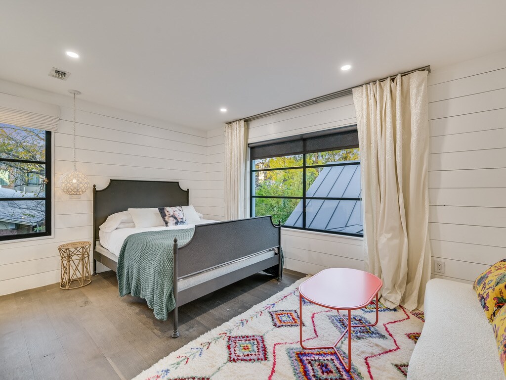 Uno de los dos dormitorios secundarios en la residencia principal, una cama tamaño queen.  Pequeño sofá sofá y mesa de centro.  Armario de tamaño completo con amplios cajones, estantes y espacio para colgar la ropa.