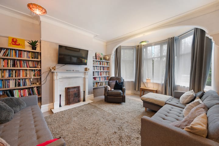 Просторна всекидневна с разтегателен диван, телевизор и удобно кресло