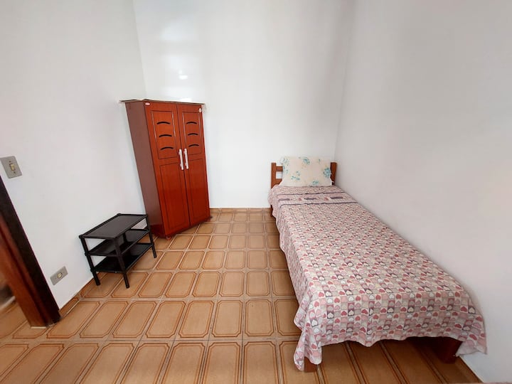 Slaapkamer 3, compacter, met 1 eenpersoonsbed en nog 1 uitschuifbed. Het heeft een plafondventilator, 1 kleine kledingkast en 1 plank om je spullen te ondersteunen.