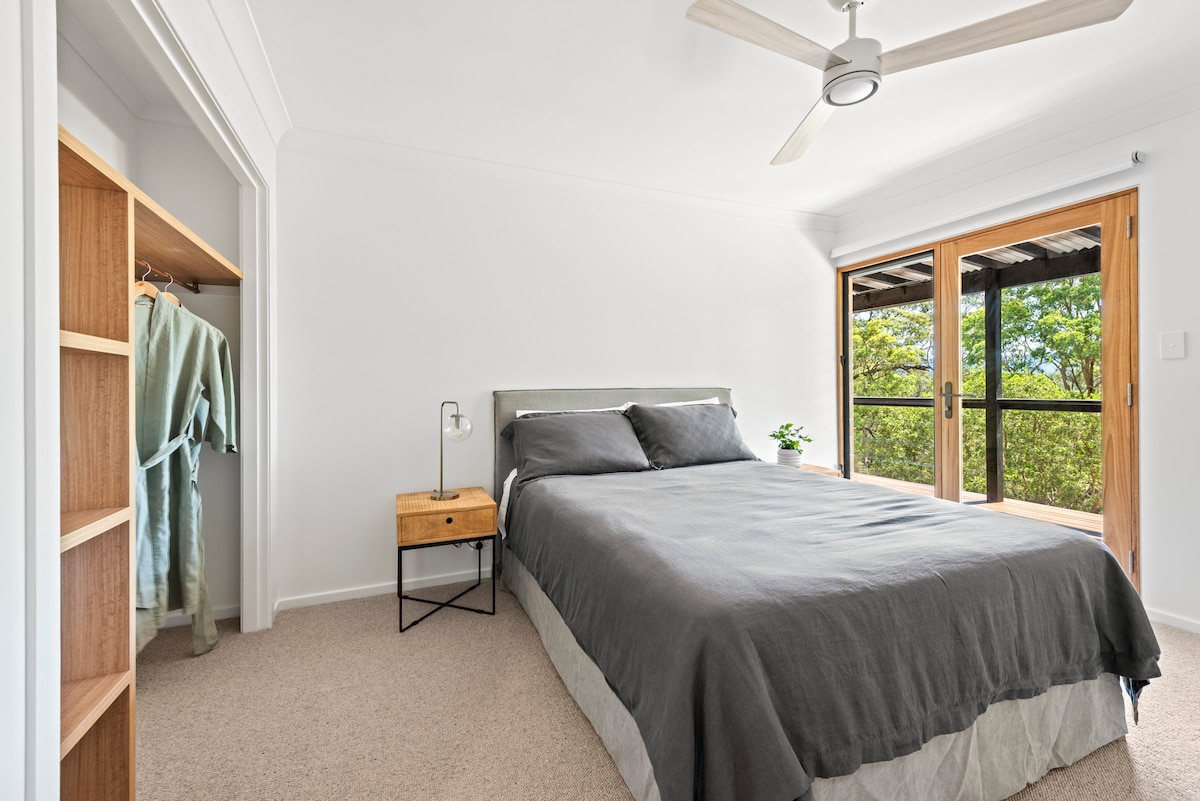 Cama tamaño queen con ropa de cama francesa.  Vistas a las copas de los árboles al arroyo Conjola y al escarpado, con puerta que se abre a la terraza.
Esta habitación también tiene una cama individual (si es necesario).