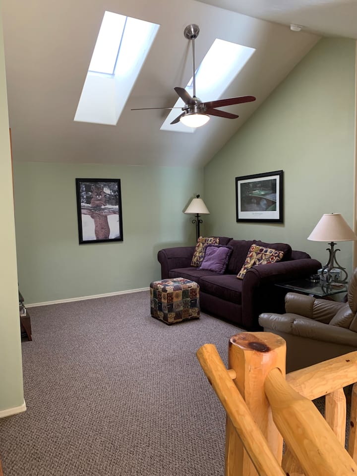 חדר שינה למעלה עם ספה נפתחת בחלק העליון של המדרגות