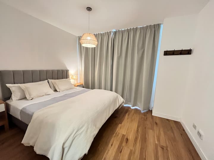 Hoofdslaapkamer met kingsize bed en eigen badkamer in de kamer.