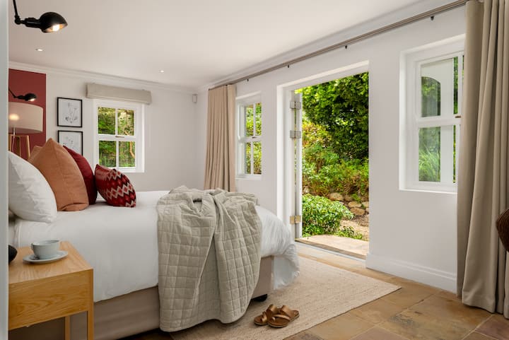 غرفة نوم 2 مع أبواب تؤدي إلى الحديقة
