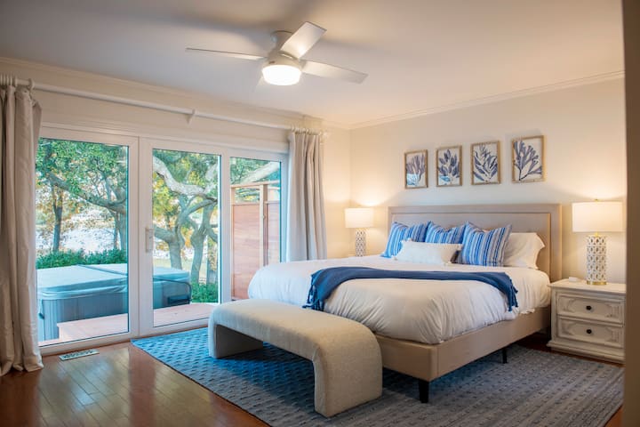 Prozračna bračna soba s prekrasnim pogledom i kliznim vratima do terase s masažnom kadom i vanjskog tuša.