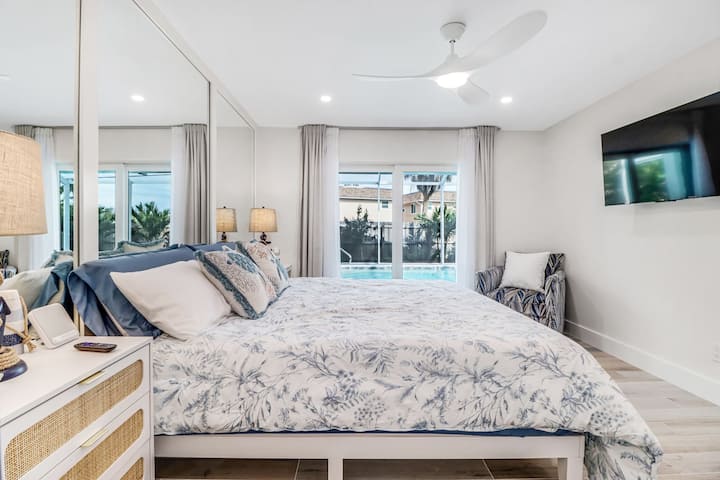 Hlavná spálňa s posuvnými dverami vedúcimi k vyhrievanému bazénu. Televízor s držiakom na stenu s plným pohyb