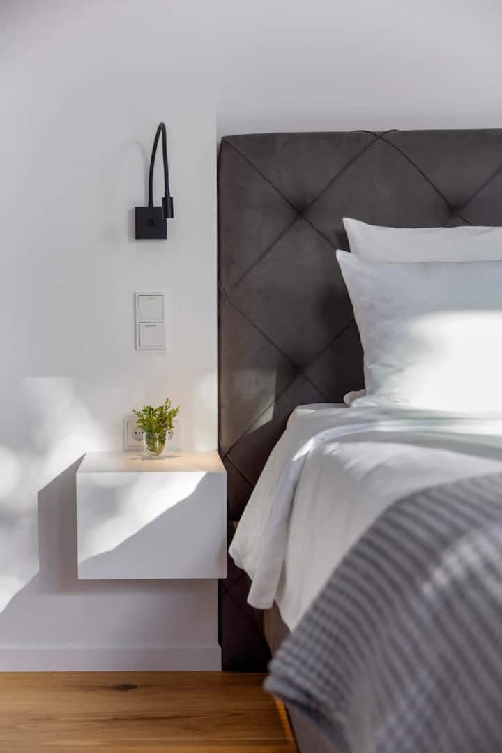 פשטות מתוחכמת — להחליק לתוך המותרות של מצעים פריכים ונוחות מותאמת בחדר המיועד ללילות נינוחים.