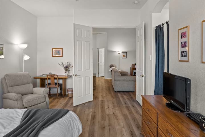 Veľká, pohodlná hlavná spálňa s dvojitými dverami s výhľadom na obývaciu izbu.