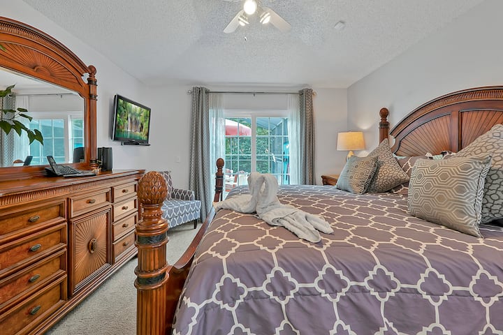 غرفة نوم رئيسية بسرير مريح بحجم كبير. يحتوي على تلفزيون ذكي يحتوي على حساب NETFLIX المبرمج بالفعل وتطبيق كابل Spectrum. يمكنك الوصول بسهولة إلى حمام السباحة وإطلالة رائعة. استرخ واصنع ذكريات جديدة لا تنسى 