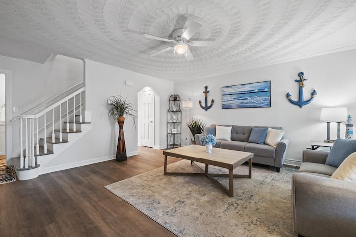 Sala de estar atualizada com piso LVP, TV montada, ventilador e espaço aberto.