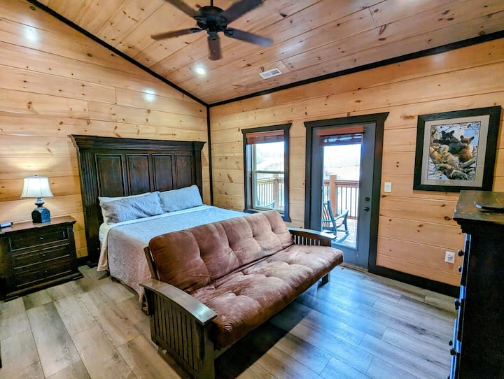 Bedroom 4 with high ceiling, patio access, sofa and TV. 