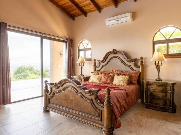 El lujo te espera en la suite principal con una cama tamaño king, vistas a la piscina y acceso a la terraza.