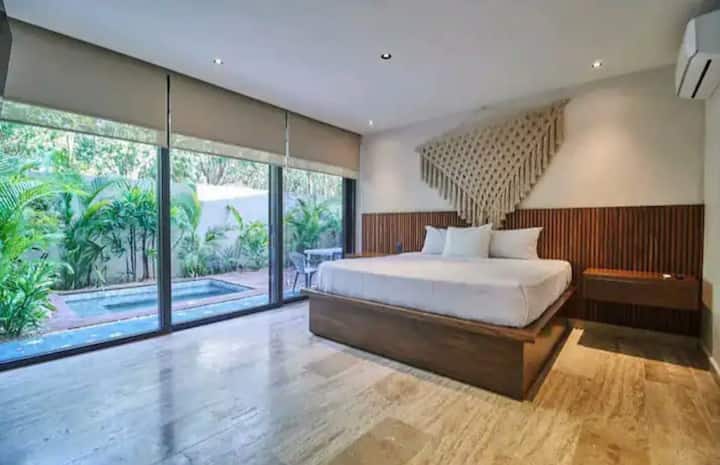 Hlavná recamara s prístupom na vonkajšiu skladovaciu terasu vedľa súkromného bazéna.