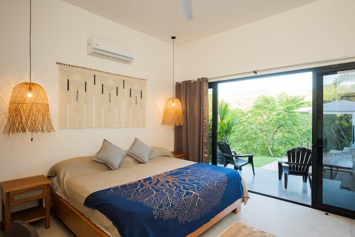 This is bedroom #1,  a cozy retreat designed for two, embrace natural materials that reflect the beauty of the outdoors. Furniture crafted from bamboo, rattan, cedar, introduces an organic and earthy feel, creating a seamless connection to nature.