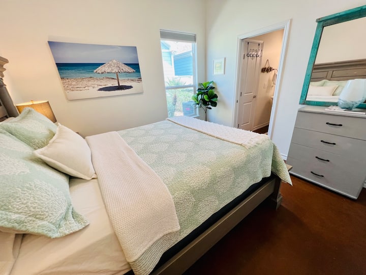 Guest bedroom with Queen bed and dresser, and ensuite bathroom.
