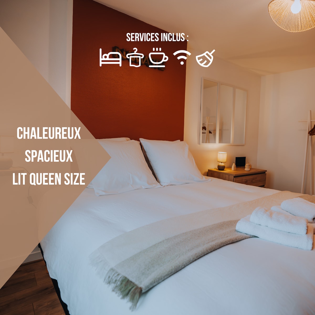 The sleeping area features a queen-size bed with crisp white linens, complemented by a soft throw and two neatly folded towels. A warm accent wall adds a cozy touch, while a bedside lamp and a mirror provide practical and decorative elements.