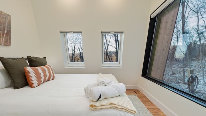 At the front of the house, find yourself in the primary bedroom with en-suite bathroom and a 10' long trapezoid window.