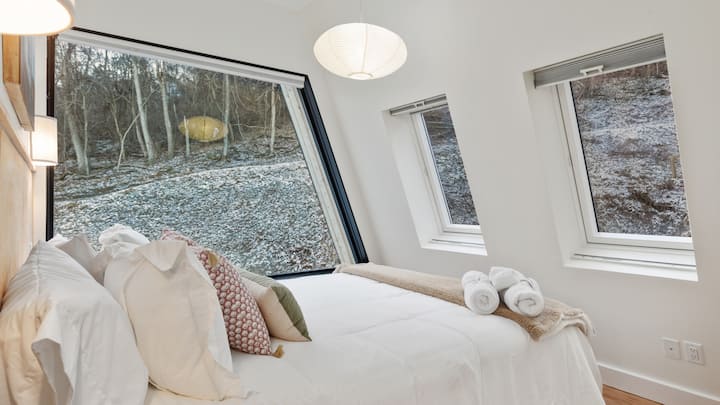 This room is facing the front of the house and contains a massive trapezoid window to take in the surrounding nature.