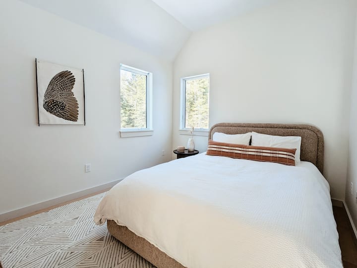 El segundo dormitorio de invitados en la segunda planta cuenta con una cama tamaño queen con lujosa ropa de cama y un entorno sereno. Esta habitación tiene su propia bomba de calor/unidad de aire acondicionado y ventilador de techo para un control de temperatura personalizado. 