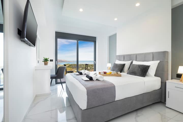 ห้องนอนพร้อมเตียงควีนไซส์เข้าถึงระเบียงได้โดยตรงพร้อมโต๊ะรับประทานอาหารกลางแจ้งและวิวทะเลที่สวยงามชั้นบนสุด