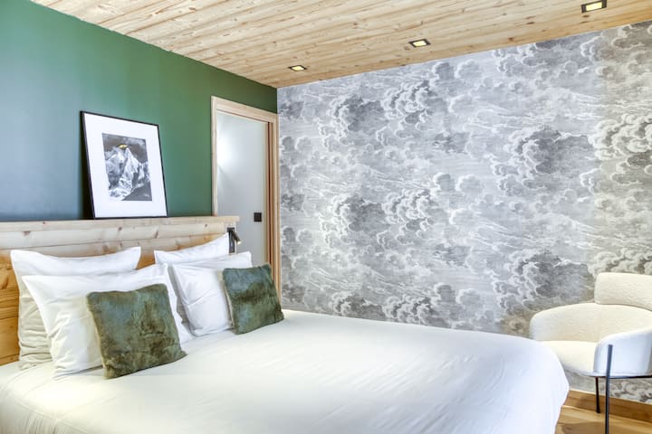 Suite principale, avec un dressing, une salle de bain élégante et une vue majestueuse sur les montagnes depuis votre lit.