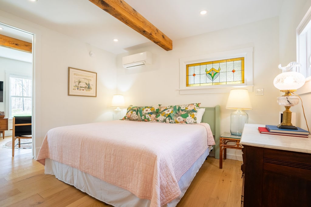 The first-floor primary bedroom has a king-sized bed with Coop pillows. Beautiful antique touches and modern amenities like radiant heat flooring and a heat pump that provides heat and AC will make for a luxurious stay.