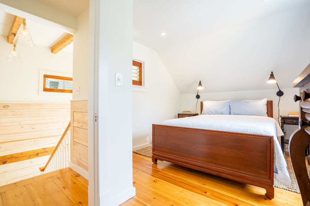 One of two bedrooms upstairs has a queen-sized bed with Coop pillows. An antique dresser and large closet provide ample storage for your belongings. Blackout curtains ensure you'll get a good night's sleep.