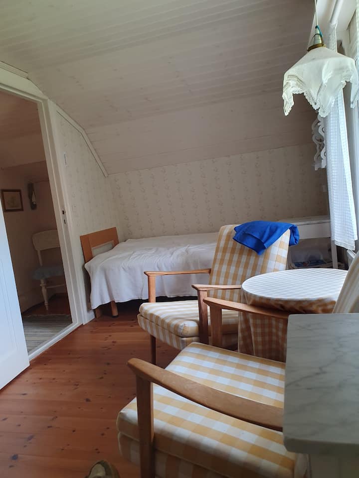 Chumba cha kulala cha Nyumba kubwa ya mbao upande wa kaskazini. Vitanda viwili vya mtu mmoja, viti viwili vya mikono, meza na kabati la nguo. 