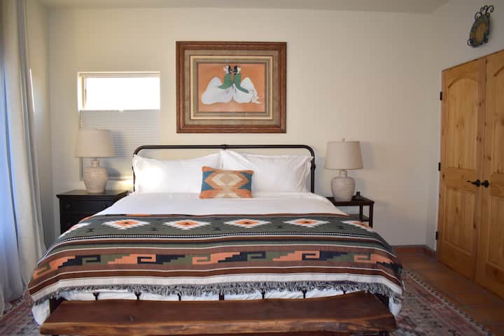 Cama tamaño king con arte RC Gorman sobre la cama. 