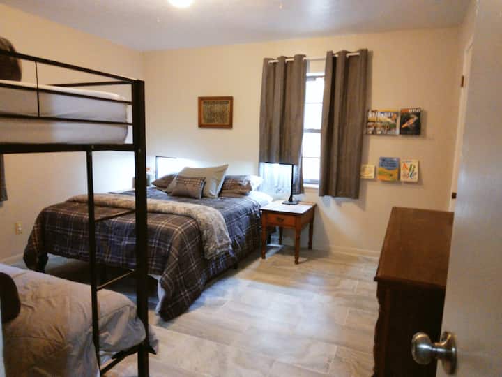 Farmhouse- Bedroom 2 of 3 bedrooms. Each bedroom has 1 queen bed with a twin bunkbed.