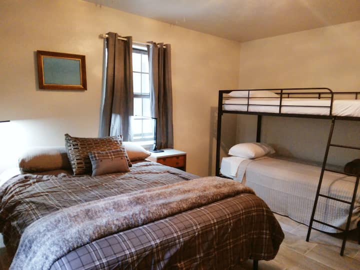 Farmhouse- Bedroom 1 of 3 bedrooms. Each bedroom has 1 queen bed with a twin bunkbed.