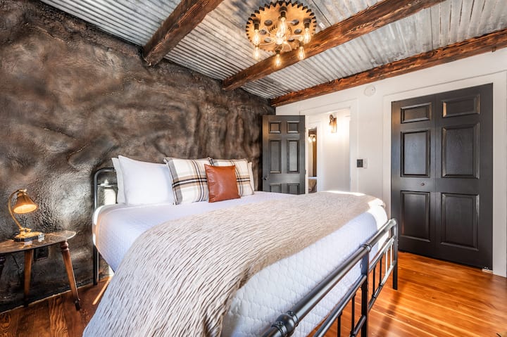 تحتوي "غرفة النوم التي تضم سرير كينج" على طاولة جانبية مع مصباح عتيق حيث يمكن شحن الأجهزة بشكل مريح ولاسلكي. تحتوي الخزانة على شماعات لملابسك ورف لتخزين إضافي ورفوف لأمتعتك لتكون في الطابق. 