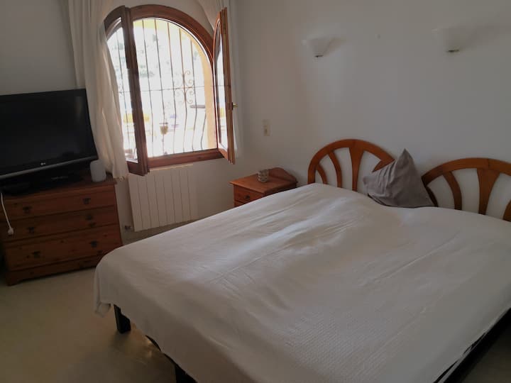 חדר שינה לצד הבריכה עם שתי מיטות נפרדות.