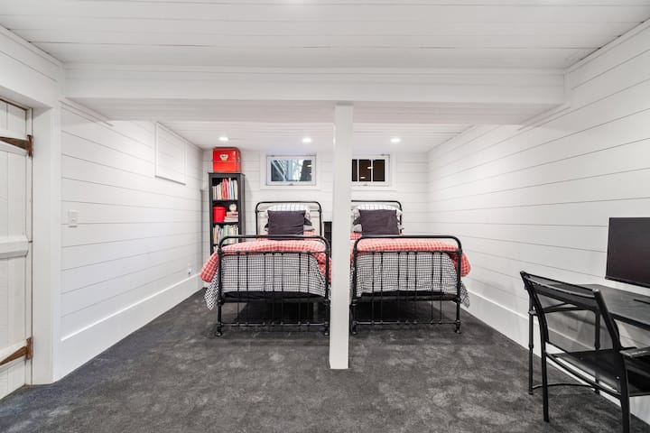 Spavaća soba 6 u podrumu s dva odvojena kreveta i prostorom za rad na daljinu.