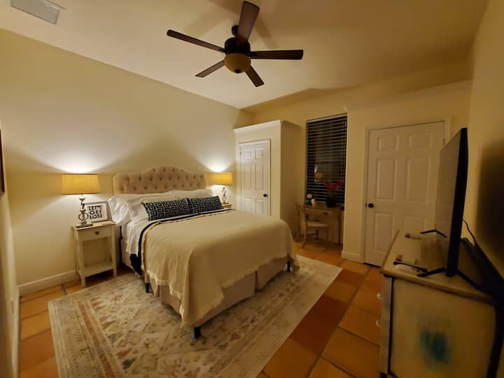 Bedroom Suite #2 at night. Queen bed, duel closets, small desk, dresser, and 55" 4KTV