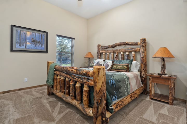 Odpočívajte v druhej spálni na primárnom poschodí s krásnou manželskou posteľou veľkosti King a očarujúcim dreveným nábytkom pre útulnú, rustikálnu atmosféru.
