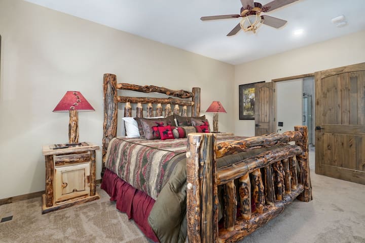 Oddýchnite si vo svojej ohromujúcej hlavnej spálni s luxusným skutočným dreveným nábytkom a krásne tematickými umeleckými dielami pre rustikálne, ale elegantné útočisko.