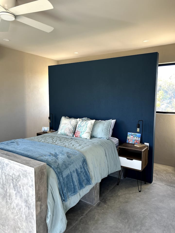 Comfortabel queensize bed met zacht beddengoed en kofferopslag eronder.