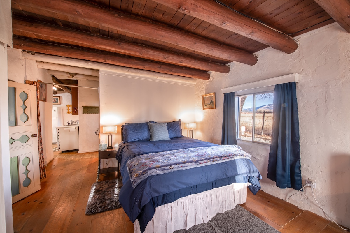 Уютна спалня с двойно легло, плюшени килими и просторен отворен килер с поставки за багаж и сензорно осветление с USB. Подът от лявата страна може да има лек наклон поради възрастта на дома, но е идеален за отдих и разпускане.