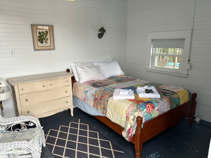 חדר שינה עם מיטה זוגית וחדר רחצה צמוד. חדר השינה וחדר הרחצה האלה מנותקים מהחלק הראשי של הקוטג' ומחוברים דרך מרפסת המרפסת