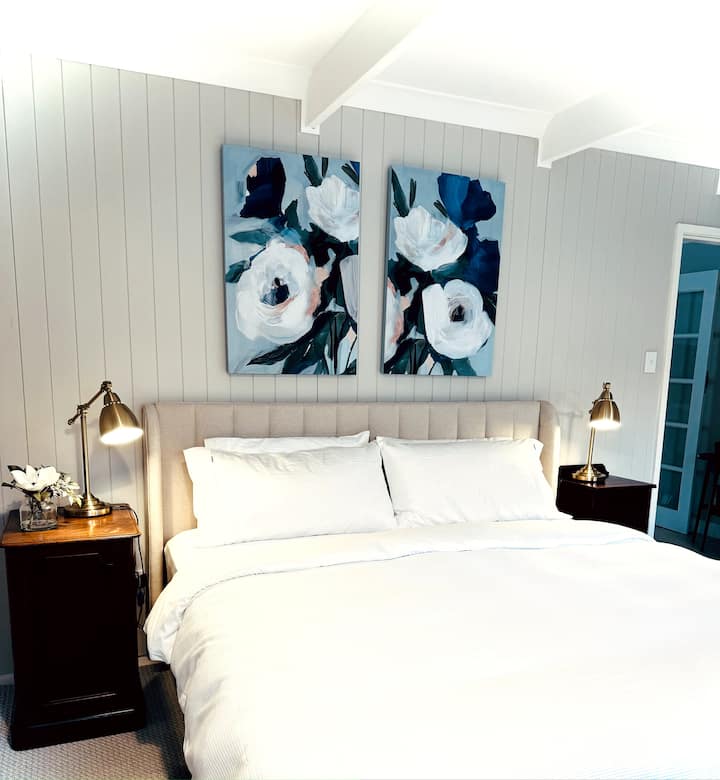 Large bedroom with plenty of wardrobe storage, desk and occasional chairs