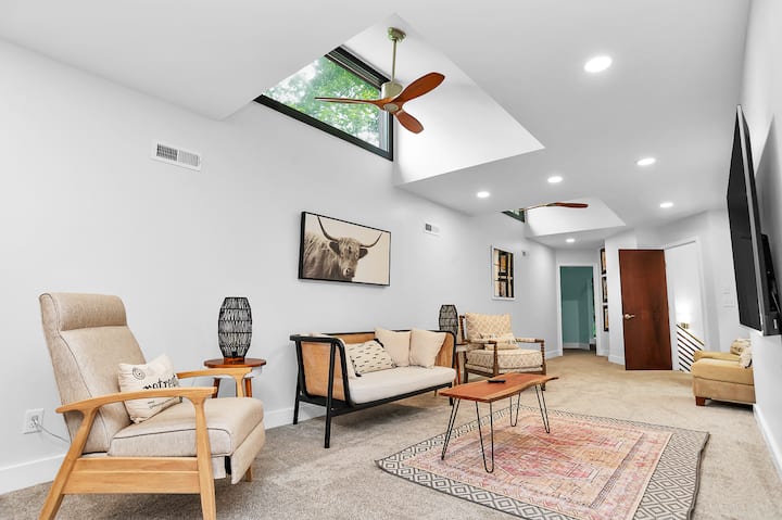 Boven Recreatieruimte die zo groot is aan de ene kant is om te loungen, aan de ene kant om te slapen. Deze kamer fungeert als zowel een slaapkamer als een 65-inch smart-tv/hangplek. 