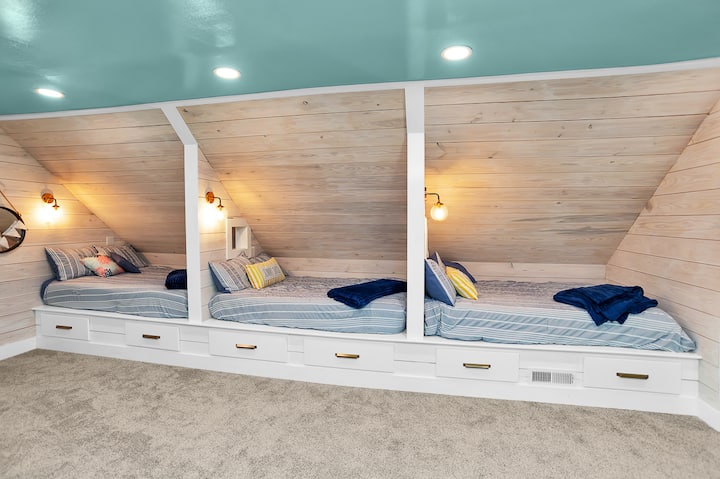 3 full size ingebouwde stapelbedden zijn een kinderdroom met aangepaste 'pass through' voor late night giggles. Elk stapelbed 'hut' heeft zijn eigen licht dat vanuit bed kan worden in-/ uitgeschakeld, evenals een stopcontact voor het opladen van apparaten. 