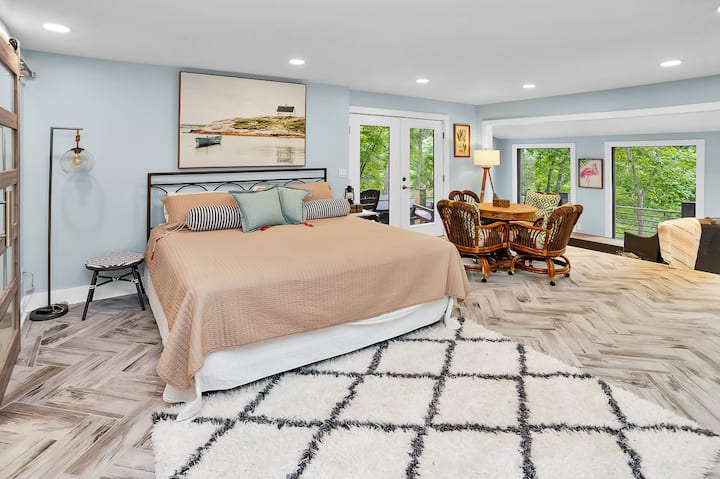 Dit is de hoofdslaapkamer op de benedenverdieping van de woning. Deze kamer heeft een eigen buitenverbinding met het bubbelbad en de patio. Deze kamer biedt een weids uitzicht op het meer en  heeft veel natuurlijk daglicht. Vroege vogels zijn dol op deze ruimte. 