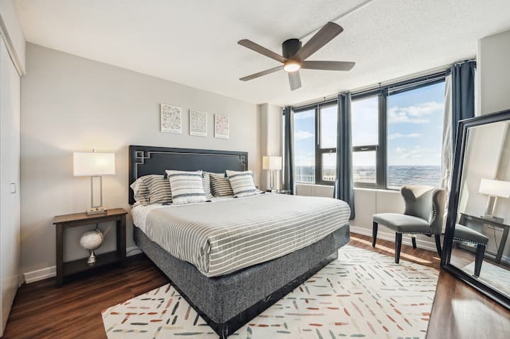 Tweede slaapkamer met comfortabel kingsize bed., smart-tv en een grote spiegel.