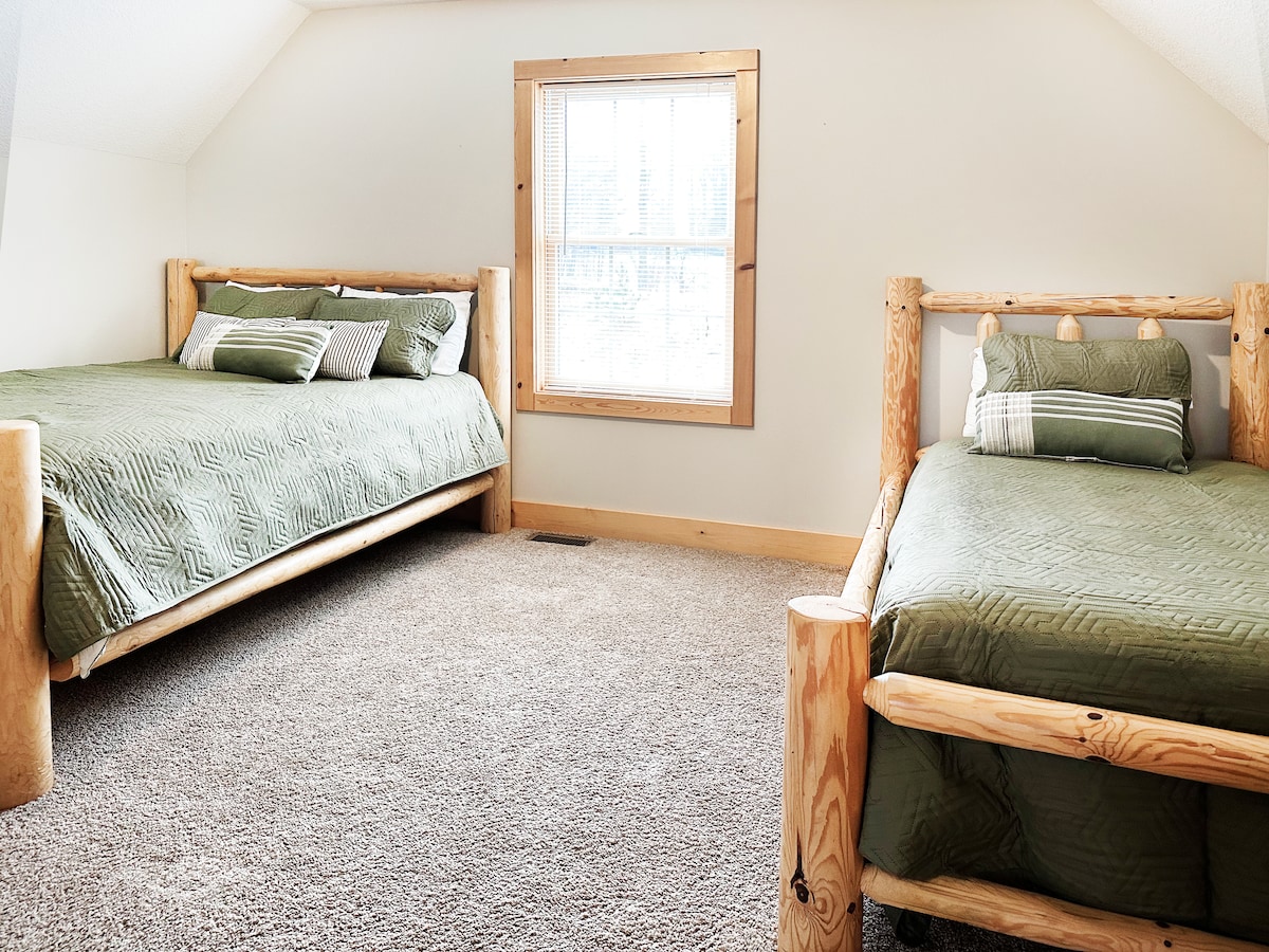 上层卧室设有一张标准双人床和一张双人床，还有一个梳妆台和一个行李箱架。 从楼梯顶部的阁楼楼梯口进入。