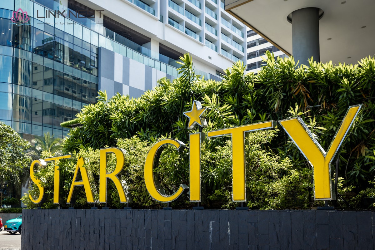 The image features the prominent signage of Star City, displayed in bold yellow letters against a backdrop of greenery. The modern architecture of the surrounding buildings reflects the vibrant city atmosphere. Clear blue skies complete the attractive entrance of the hotel.