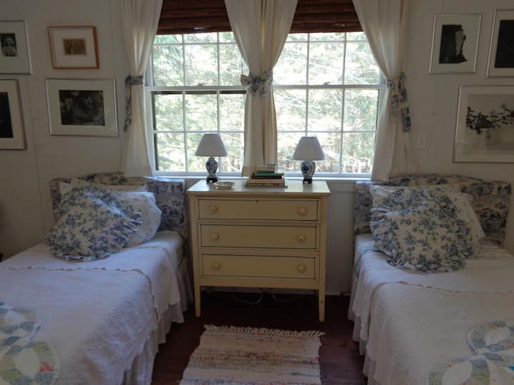 Chumba cha kulala cha ghorofani chenye vitanda pacha na picha za kale.